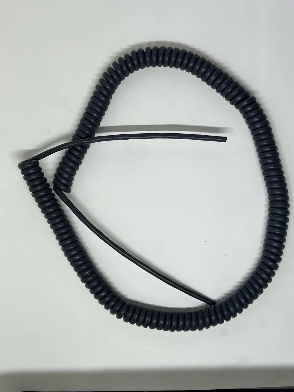 Autac retractile power cords in red and black coiled configurations