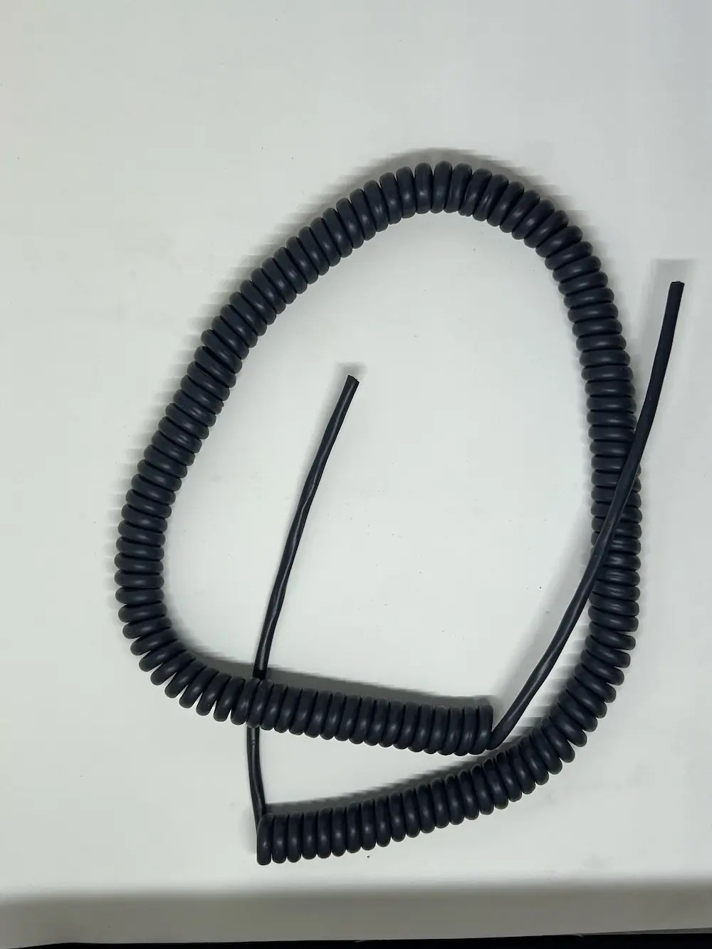 Assortment of Autac coiled cords showing different gauges and colors